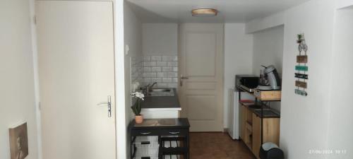 une petite cuisine avec un évier et un comptoir dans l'établissement A l ombre du figuier, à Cagnac-les-Mines