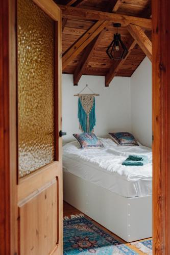 a bed in a room with a wooden ceiling at Dom na Zaciszu Charzykowy in Charzykowy