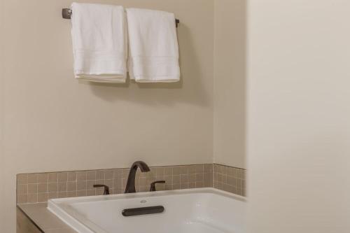 a bathroom with a sink and towels on a wall at Mountain Lake Condo | Unit 102B in Big Sky