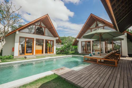 a villa with a swimming pool and a house at Arpana Luxury Private Pool Villas in Jimbaran