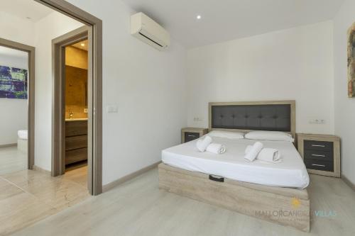a bedroom with a large white bed with white pillows at Villa Iola a 150m de la playa ideal para familias y amigos in Playa de Muro
