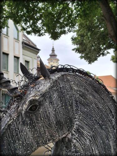 a metal horse statue in front of a building at Hotel Unicornis in Eger