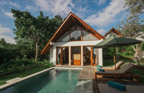 a villa with a swimming pool and a house at Arpana Luxury Private Pool Villas in Jimbaran