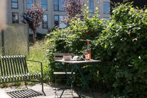 a table with a bottle of wine and a glass at The Beach Gardens by Daniel&Jacob's in Copenhagen