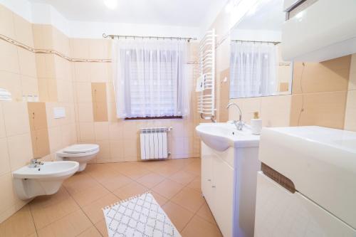 a bathroom with a toilet and a sink at Promenada Apartamenty i Domek Nad Jeziorem in Mikołajki
