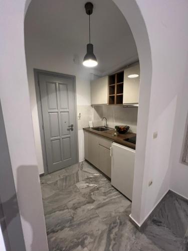 a kitchen with an archway leading into a kitchen with a sink at CAELI PAROS by Kostas & Joanna Studios in Logaras