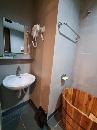 a bathroom with a sink and a wooden tub at Fahrenheit 88 Suites Bukit Bintang C 3R in Kuala Lumpur