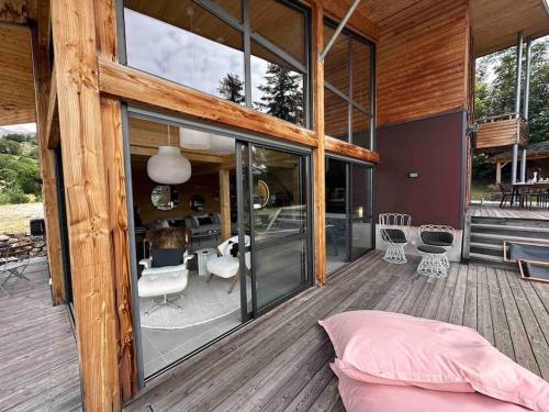 a house with glass doors and a bed on a deck at Chalet d'architecte avec vue panoramique in Allos