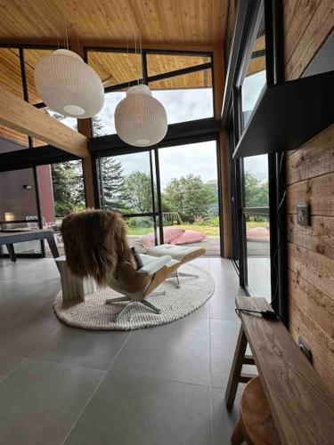 a woman sitting in a chair in a living room at Chalet d'architecte avec vue panoramique in Allos