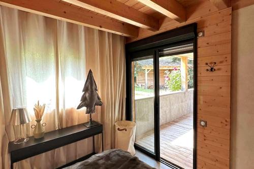 a bedroom with a sliding glass door to a porch at Chalet d'architecte avec vue panoramique in Allos