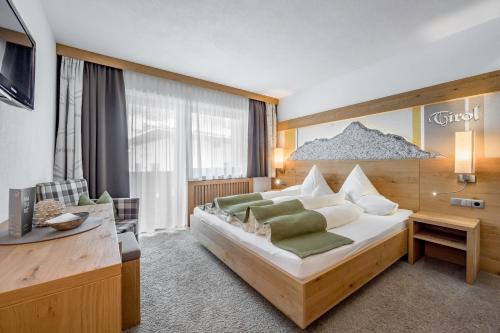 a hotel room with a bed and a desk at Hotel Sportpension Carinthia in Sölden