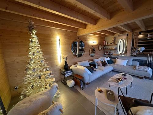 a living room with a christmas tree in a room at Chalet d'architecte avec vue panoramique in Allos