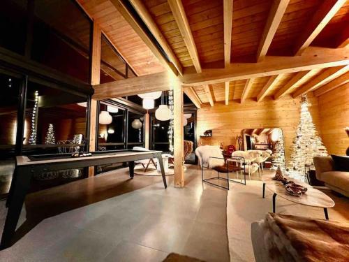 a living room with a ping pong table and a fireplace at Chalet d'architecte avec vue panoramique in Allos