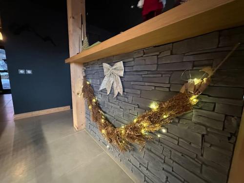 a brick wall with a bow and lights on it at Chalet d'architecte avec vue panoramique in Allos