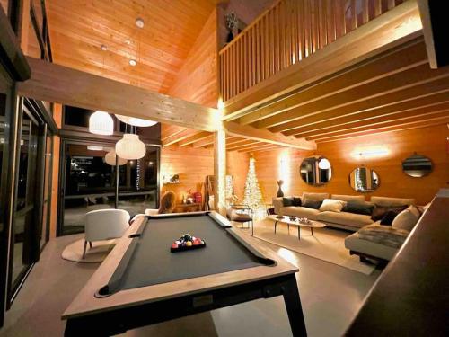 a living room with a pool table in it at Chalet d'architecte avec vue panoramique in Allos
