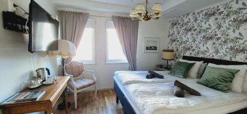 a bedroom with a bed with a desk and a bed sidx sidx sidx at Slite Badhotell in Slite