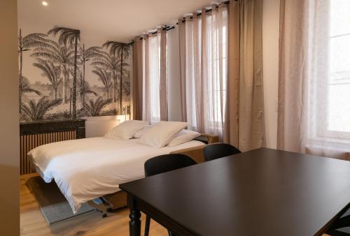 une chambre d'hôtel avec un lit et une table dans l'établissement Cœur de Metz Balnéo - La Suite 2, à Metz
