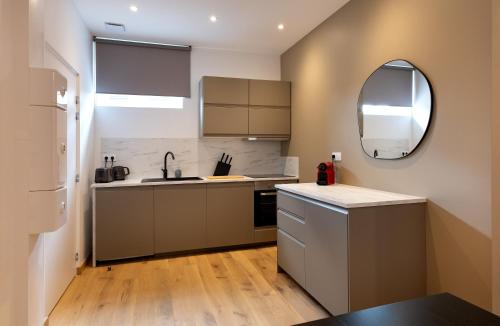 - une cuisine avec un évier et un miroir dans l'établissement Cœur de Metz Balnéo - La Suite 2, à Metz