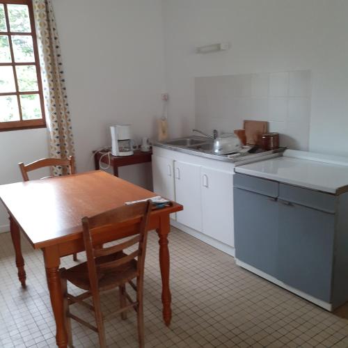 a kitchen with a wooden table and a sink at Appartement vue sur l'Eure in Soulaires