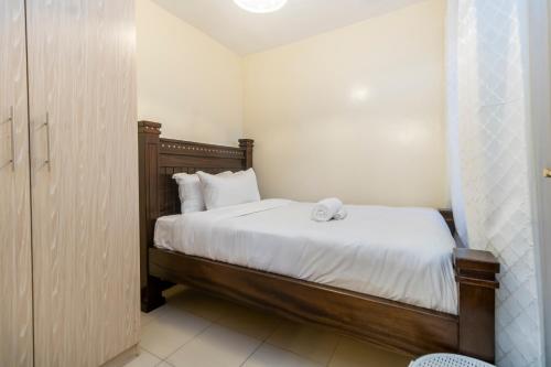 a bedroom with a bed with white sheets and white pillows at Serenity Retreat - 2 Bed Apartment with Pool & Gym in Nairobi