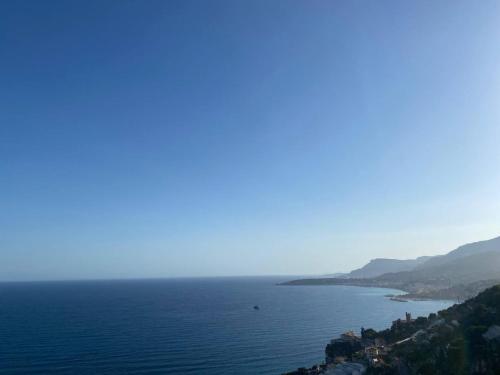 a large body of water with a town on a hill at Attico sul mare in Grimaldi