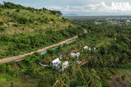 an aerial view of a train traveling down a hill at StayVista at Shwaas 4BR Mysore with Private pool and landscape in Mysore