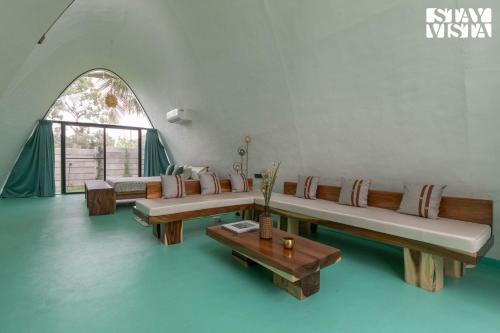 a living room with couches and a table at StayVista at Shwaas 4BR Mysore with Private pool and landscape in Mysore
