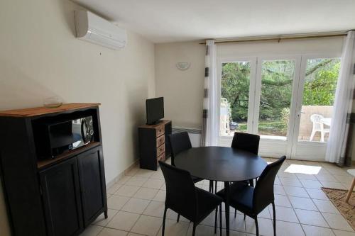 un salon avec une table, des chaises et une télévision dans l'établissement Studio 30 m2 proche de Porticcio et d'Ajaccio, à Eccica-Suarella