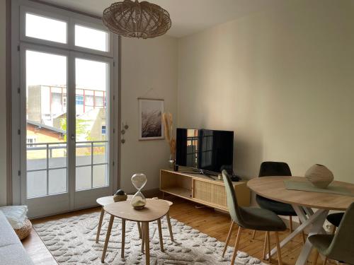 un salon avec une table et une télévision dans l'établissement Coeur de Toulouse, appartement paisible et charmant, à Toulouse