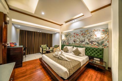 - une chambre avec un lit doté d'une tête de lit verte dans l'établissement Hotel Saffron Leaf, à Dehradun