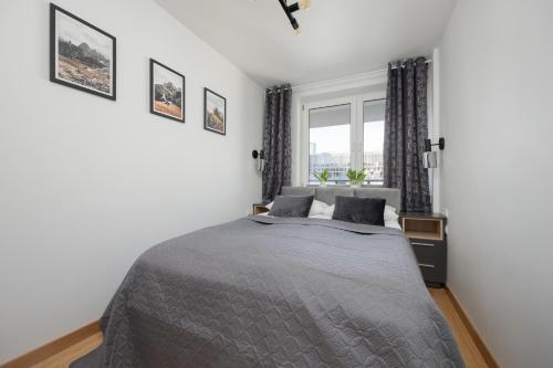 a bedroom with a large bed and a window at Beautiful Apartment with Balcony in Heart of Warsaw by Noclegi Renters in Warsaw