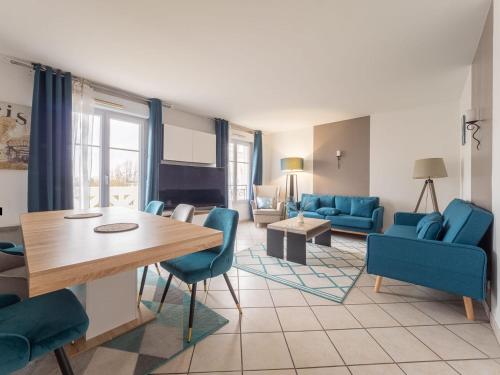 un salon avec des chaises bleues et une table dans l'établissement Appartement Serris- Val d'europe -Disney, à Serris
