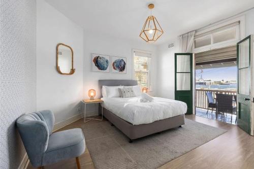 een slaapkamer met een bed, een stoel en een raam bij Vacation Home w Private Rooftop and Harbour View in Sydney