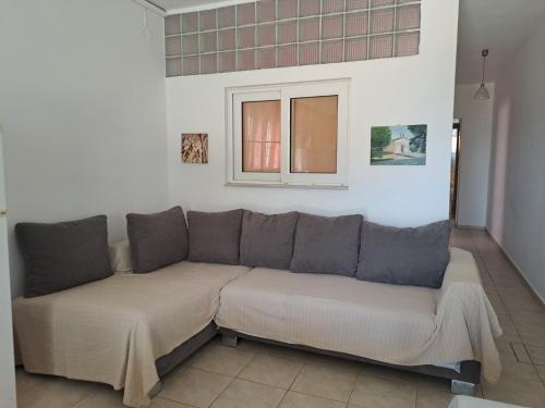 a couch in a living room with a window at Flisvos Apartments in Megalochori