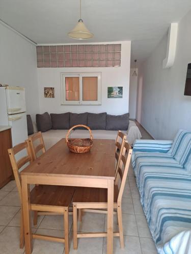 a dining room with a table and chairs and a couch at Flisvos Apartments in Megalochori