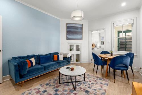 a living room with a blue couch and a table at Vacation Home w Private Rooftop and Harbour View in Sydney