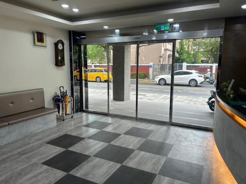 a lobby with glass doors and a checkered floor at 心園生活旅店 Xin Yuan Hotel in Hsinchu City