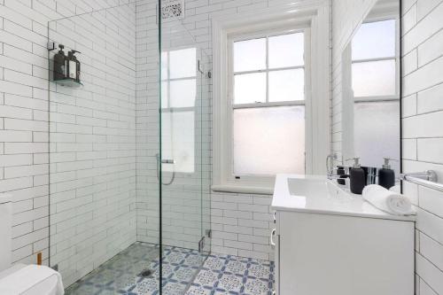 a white bathroom with a shower and a sink at Vacation Home w Private Rooftop and Harbour View in Sydney