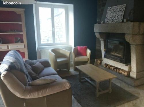 a living room with a couch and a fireplace at Gîtes du Café de la Poste in Le Buisson