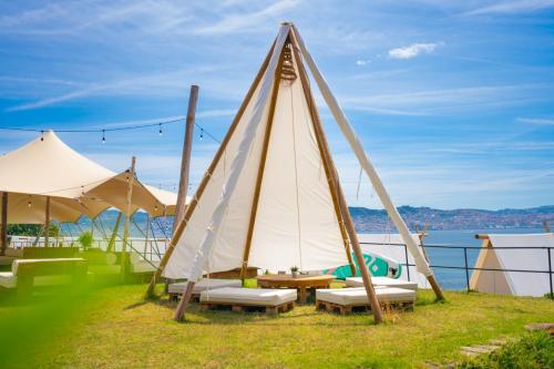a group of tents with a table and benches at Kampaoh Ría de Vigo in Moaña