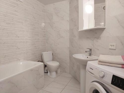 a white bathroom with a toilet and a sink at Апартаменти Класик у ЖК Яровиця in Luts'k