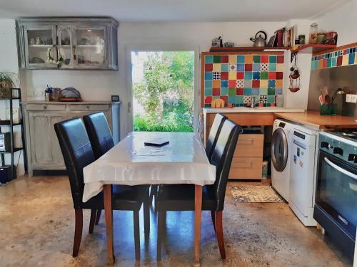une cuisine avec une table et des chaises et une cuisine avec une machine à laver dans l'établissement Maison briarde 4/6 personnes proche Disney, à Crécy-la-Chapelle