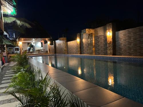 a swimming pool at night with lights on it at Oktowaves hotel in Nasugbu