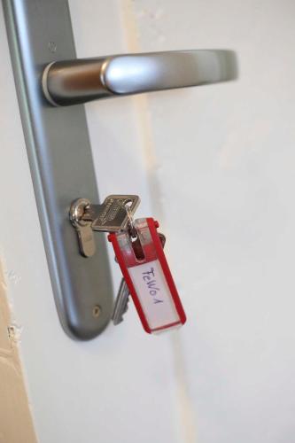 a red keychain is attached to a metal door at Ferienwohnung Werner in Jork