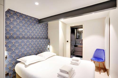 - une chambre avec un lit blanc et un mur bleu dans l'établissement Bright & cosy apartment Palais Royal, à Paris