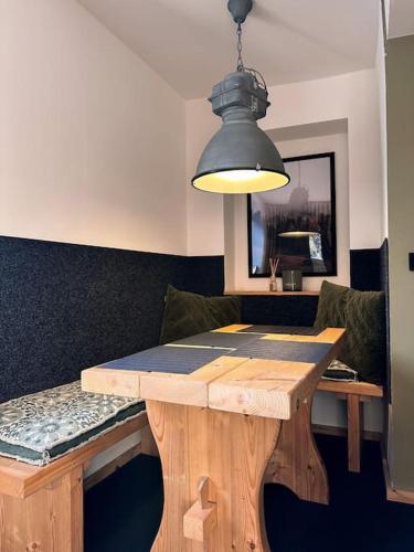 a dining room table with a black light hanging over it at Urban Apartments Weimarer Land in Buttelstedt