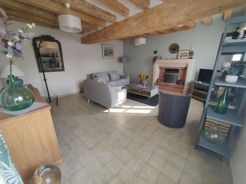 un salon avec un canapé et une cheminée dans l'établissement Le trainefeuilles,confortable,chaleureux,200m du zoo, à Saint-Aignan