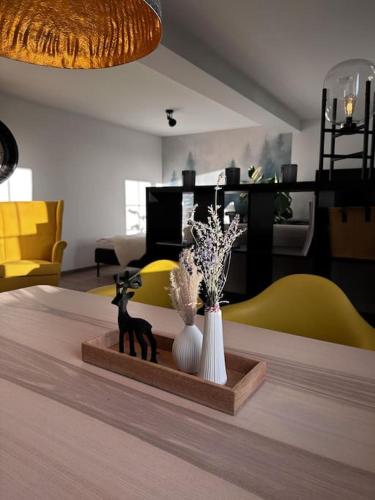 a living room with a table with two vases at Urban Apartments Weimarer Land in Buttelstedt