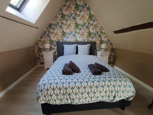 une chambre avec un lit avec deux oreillers dessus dans l'établissement Le trainefeuilles,confortable,chaleureux,200m du zoo, à Saint-Aignan