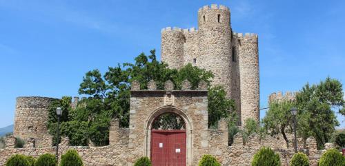 a castle with a red door in front of it at Casa Capricho in San Martín de Valdeiglesias